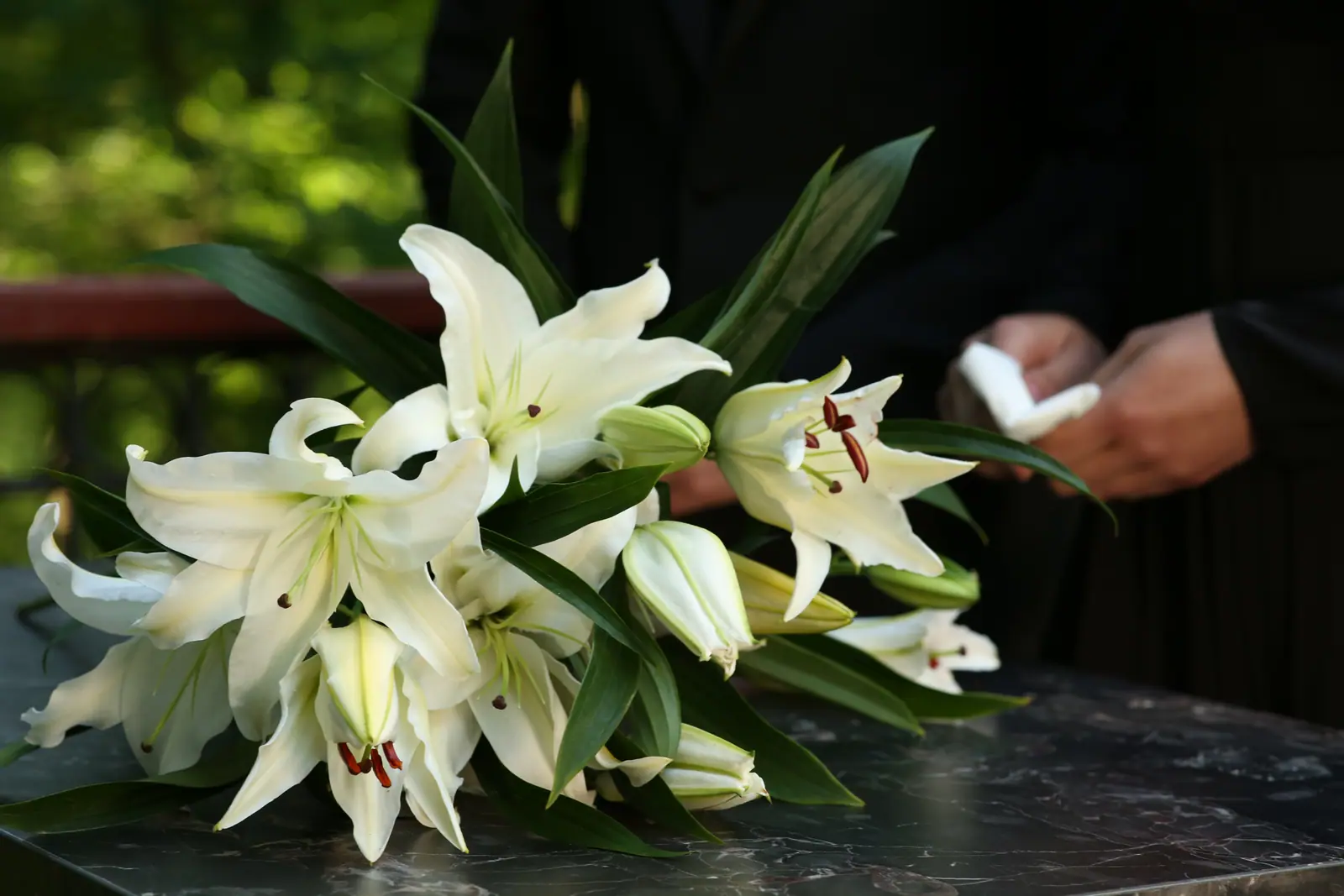 Weiße Lilien auf einem Grabstein